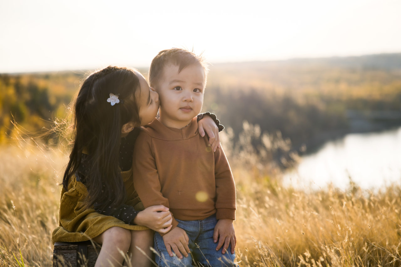 Edmonton outdoor Fall family photos - sister giving brother a kiss- by Paper Bunny Studios