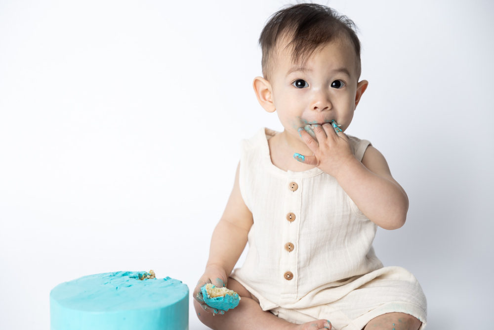 First Birthday Cake Smash photography - adorable baby eating cake by Paper Bunny Studios Edmonton