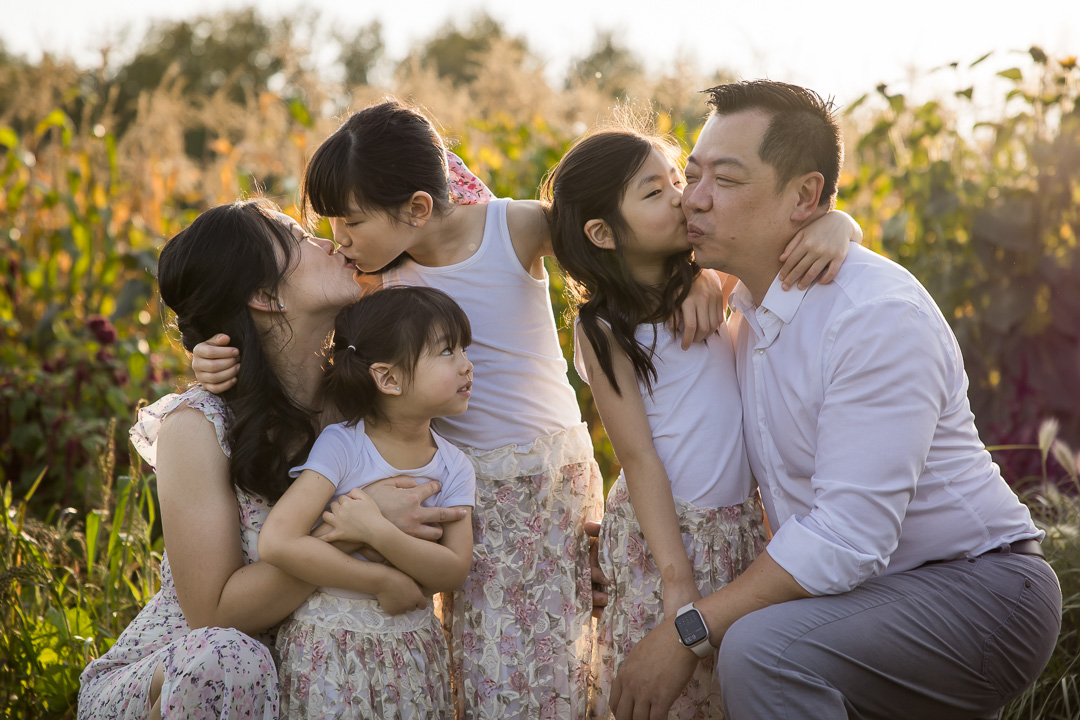 Family hugs & kisses in flower field by Edmonton documentary family photographer Paper Bunny Studios