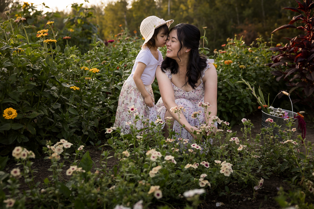 Mom getting a kiss from youngest daughter by Edmonton documentary family photographer Paper Bunny Studios