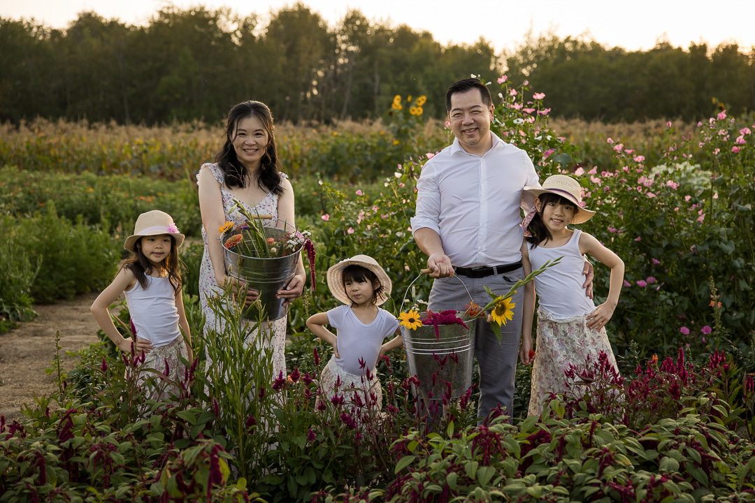 Family showing their picked flowers by Edmonton documentary family photographer Paper Bunny Studios