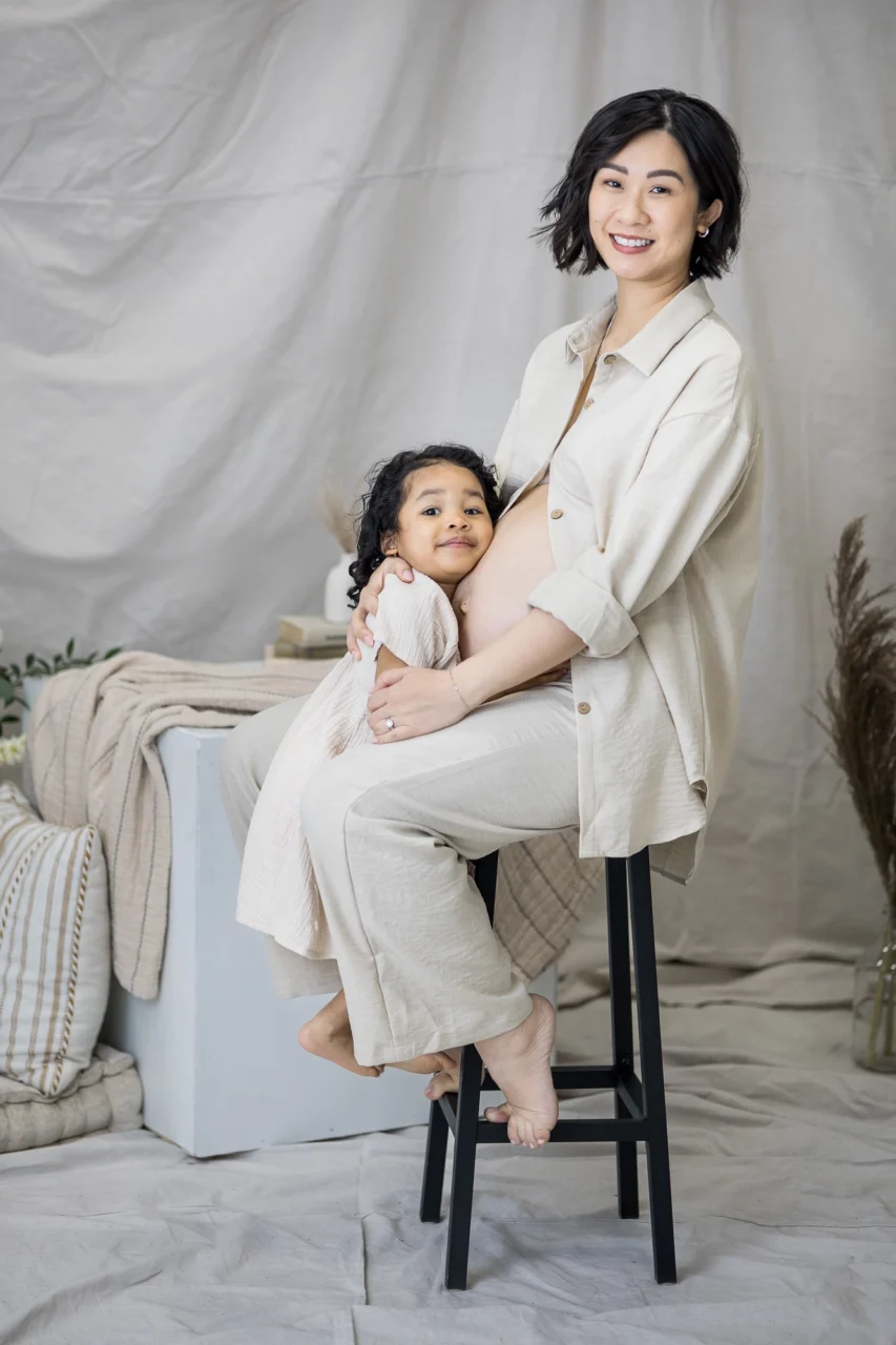 Edmonton studio maternity session of mom & big sister hugging up to bump by Paper Bunny Studios