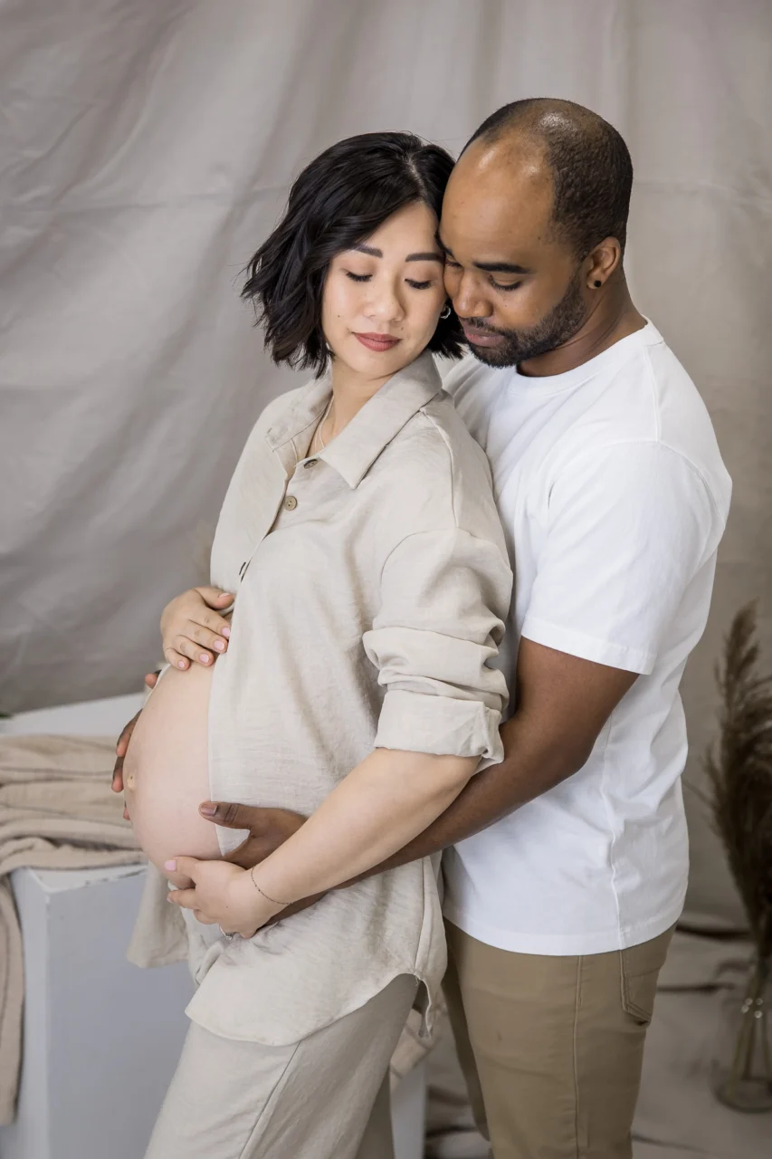 Edmonton maternity photos in studio setting of mom + dad cuddling by Paper Bunny Studios