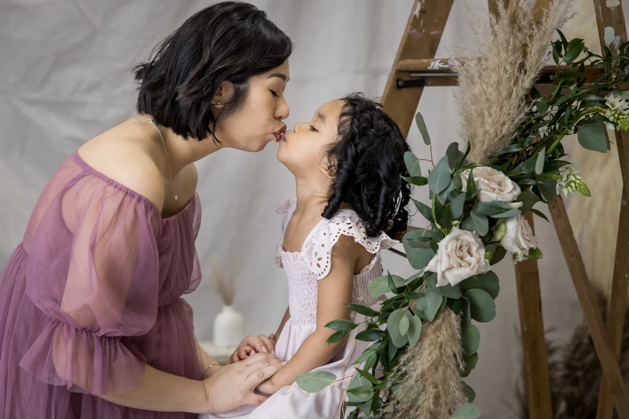 Cute portrait of mom & daughter kissing by Edmonton Family photographer Paper Bunny Studios