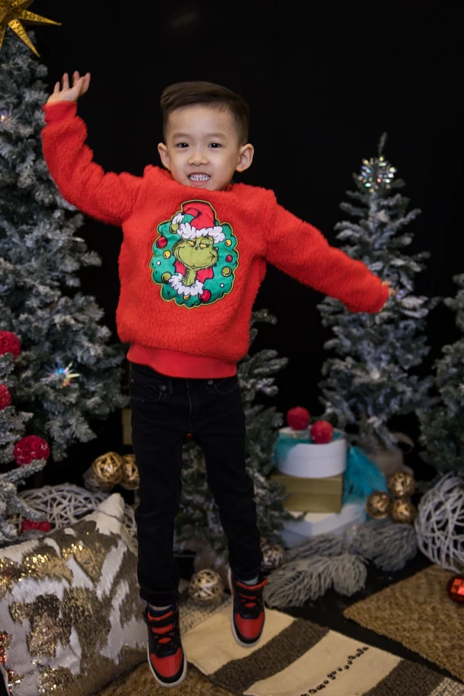 Edmonton Christmas mini session - boy jumping for joy in Grinch sweater by Paper Bunny Studios