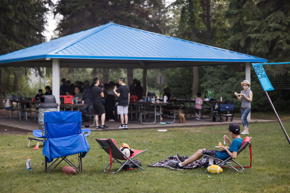 Documentary family reunion photography of kid chilling with grown ups in background by Paper Bunny Studios Edmonton