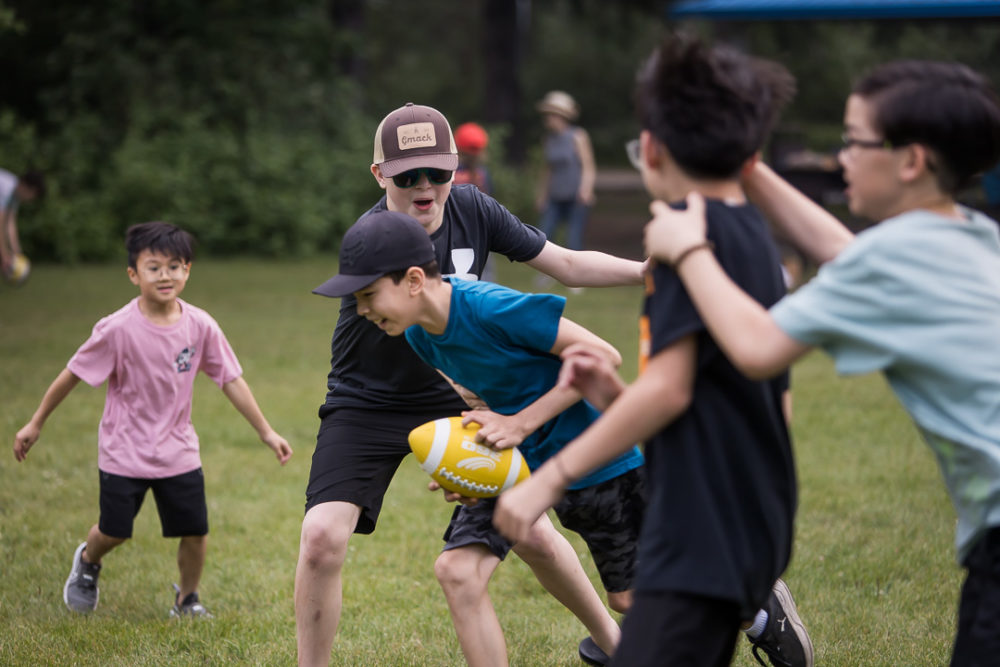 Documentary family reunion photography of kids playing touch football by Paper Bunny Studios Edmonton