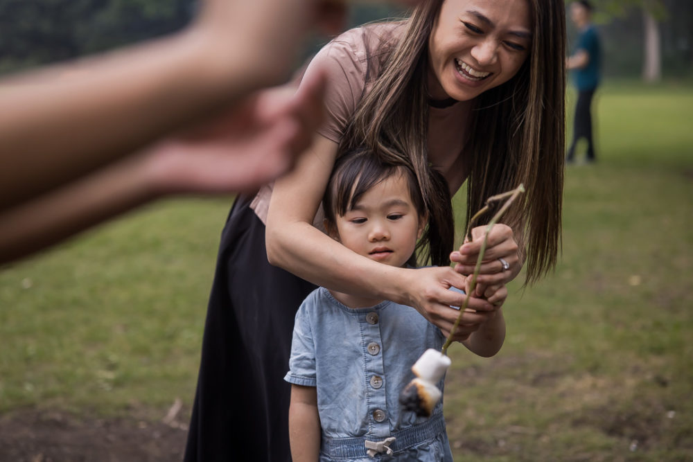 Documentary family reunion photography of mom failing while helping with marshmallow roasting by Paper Bunny Studios Edmonton