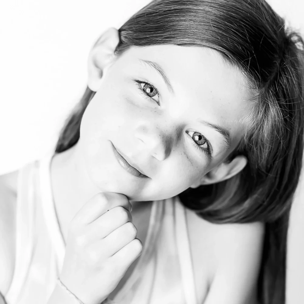 black and white portrait of a young girl doing thinker pose by Edmonton Family Photographer Paper Bunny Studios