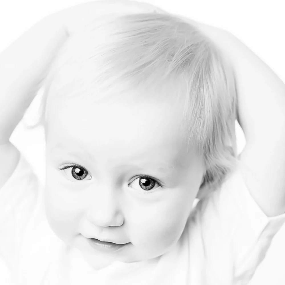 Black & white portrait of toddler with hands behind head by Edmonton family photographer Paper Bunny Studios