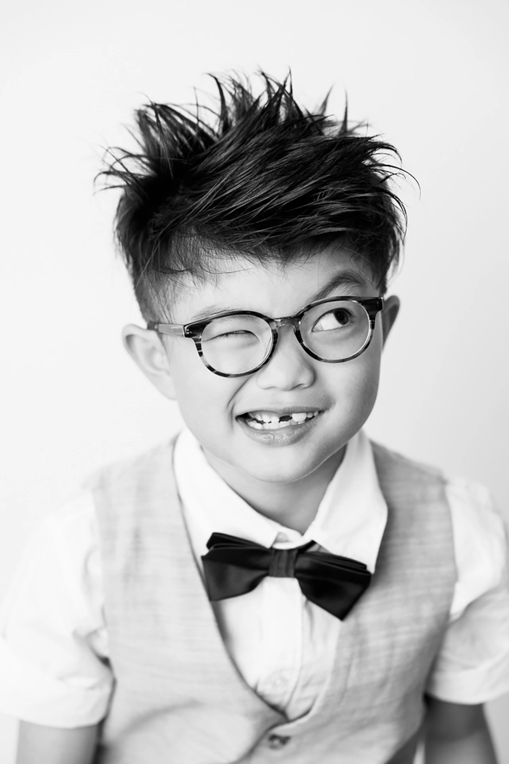 Black & white portrait photo of little boy looking dapper with silly expression by Edmonton Family Photographer Paper Bunny Studios