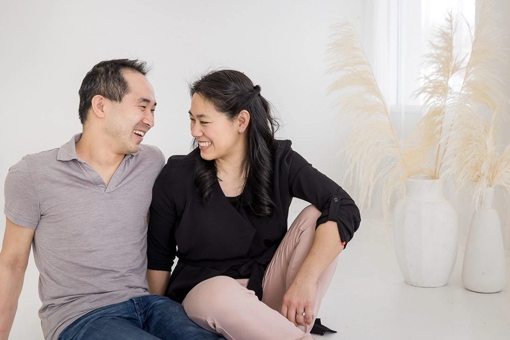 Mom and dad smiling at one another  by Edmonton Family Photographer Paper Bunny Studios