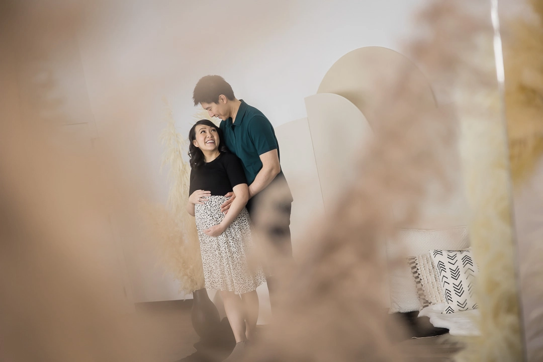 Artistic maternity photos with couple in focus & blurred foreground by Paper Bunny Studios Edmonton family photographer