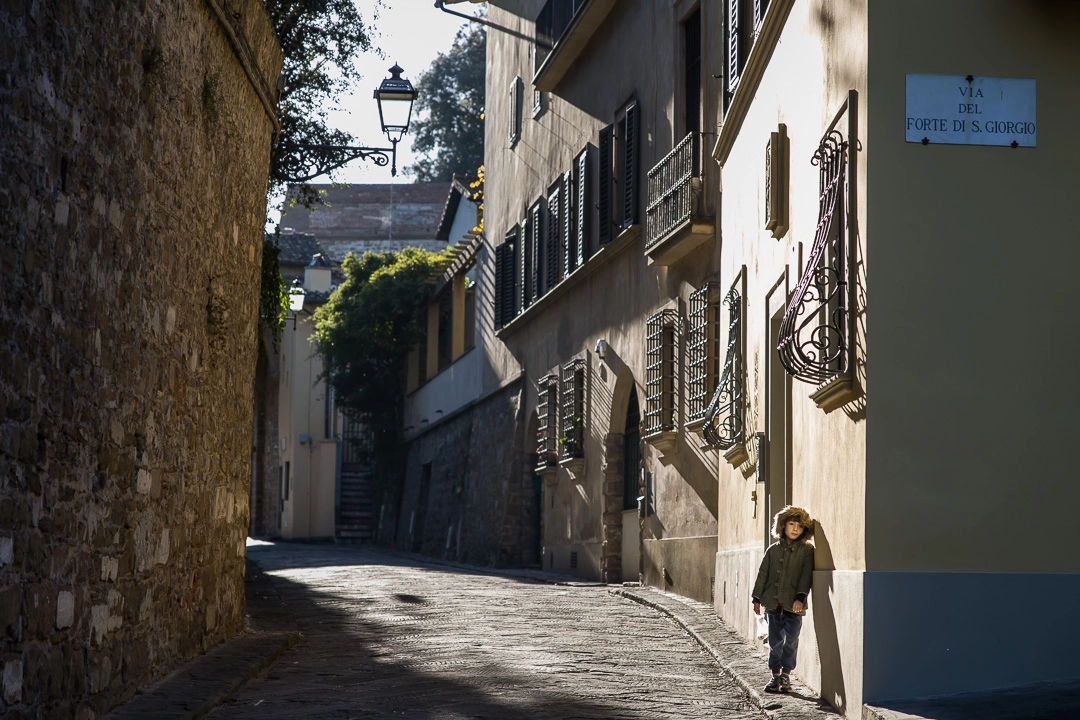 Young boy leaning against a wall in Florence by Edmonton family photographer Paper Bunny Studios