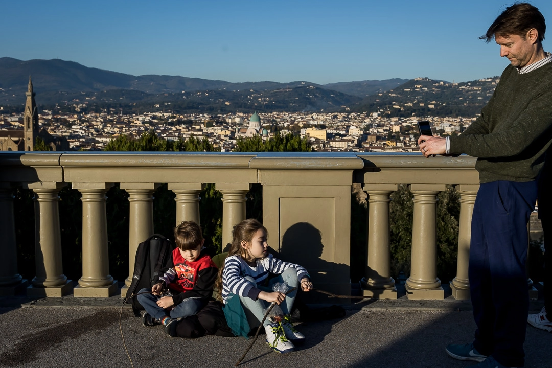 Tired kids chilling in Piazzale Michaelangelo in Florence by Edmonton family photographer Paper Bunny Studios