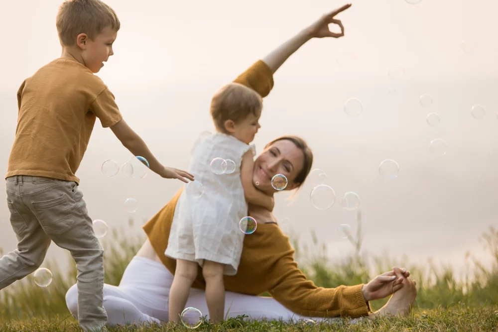 outdoor yoga family photo session by Paper Bunny Studios - mom doing a yoga pose while daughter hugs her