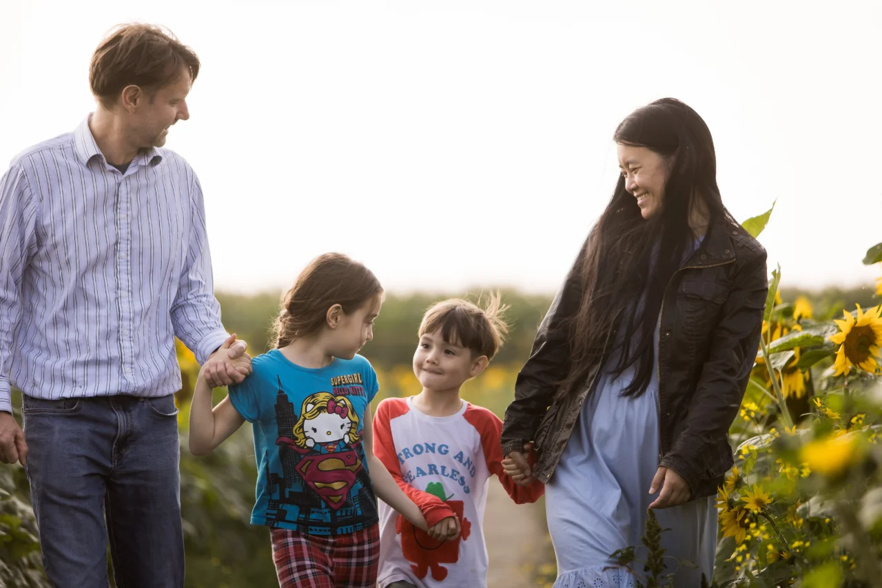 Edmonton family photos in sunflower field of family walking by fine art family photographer Paper Bunny Studios