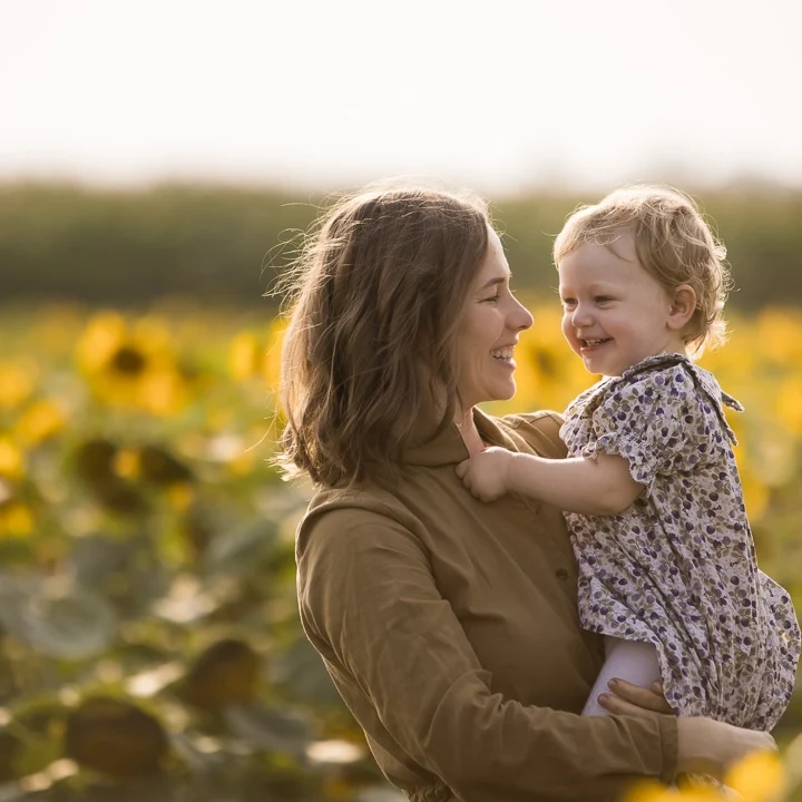 Mom and baby daughter in a sunflower field by Edmonton documentary family photographer Paper Bunny Studios