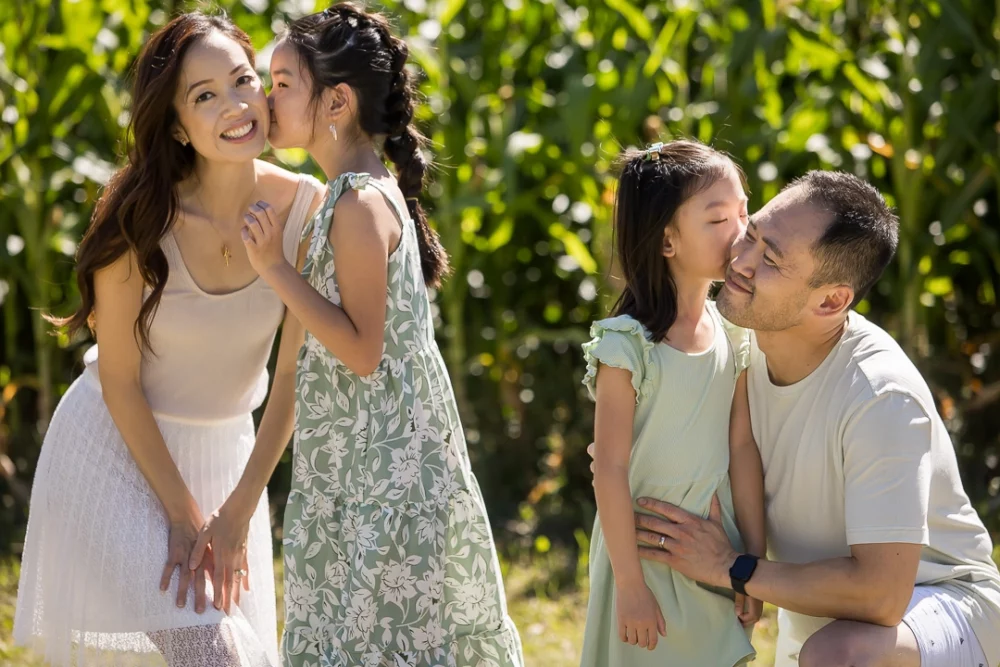 daughters giving parents a kiss by Paper Bunny Studios Edmonton 