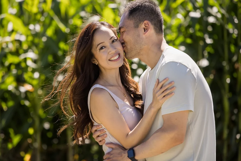 husband kissing wife on cheek by Paper Bunny Studios Edmonton 