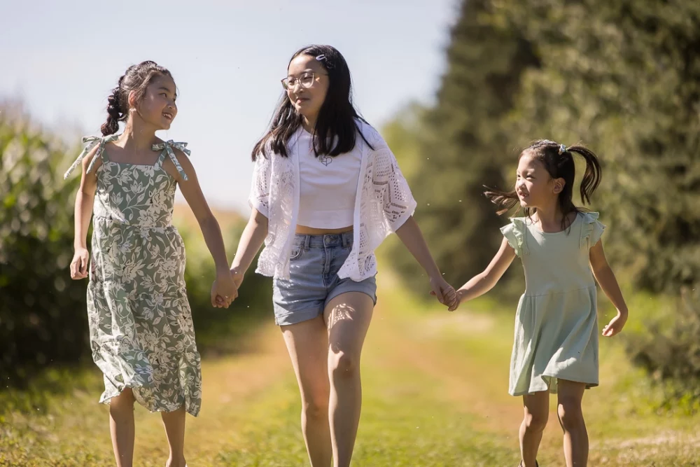 granddaughters walking through field by Paper Bunny Studios Edmonton 