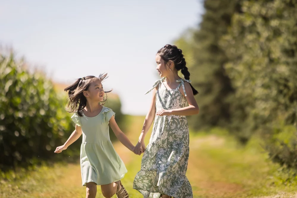 sisters walking and looking at one another by Paper Bunny Studios Edmonton 